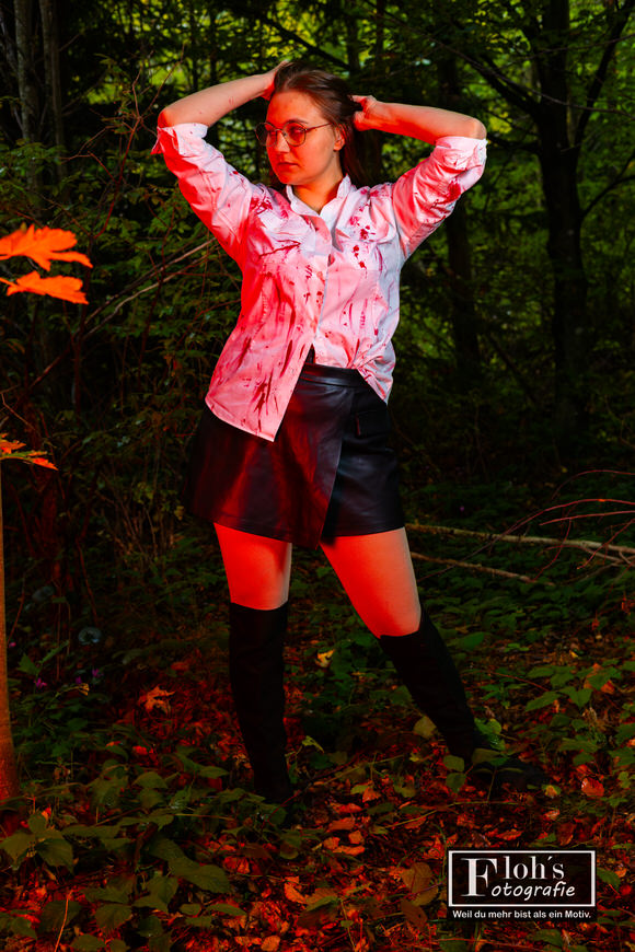 Stimmungsvolles Halloween-Portrait von Lena mit roter Farbbeleuchtung im Wald bei Weiz