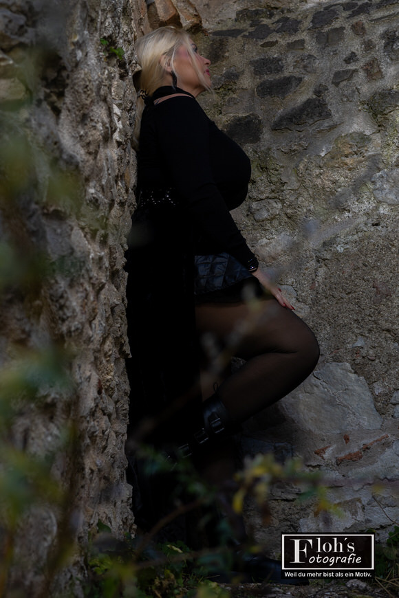 Ausdrucksstarkes Portrait von Kornelia in schwarzem Kleid bei der Burgruine Mödling, inspiriert von Halloween.