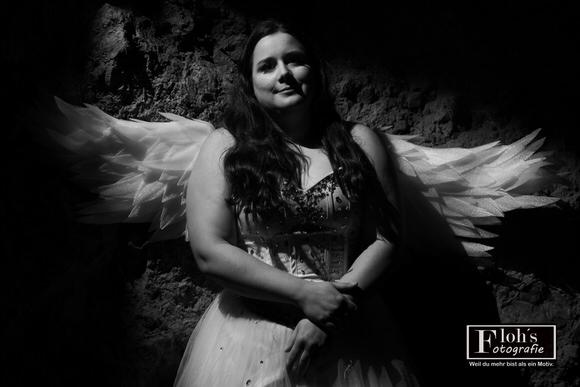 Vici als Engel im Sonnenuntergang vor Burg Hof, warme Farben und sanfte Lichtkante.