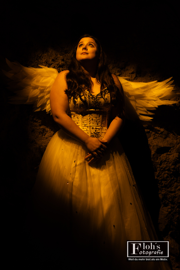 Leuchtendes Fantasy-Portrait von Vici als Engel in der Höhle, goldene Lichtinszenierung.