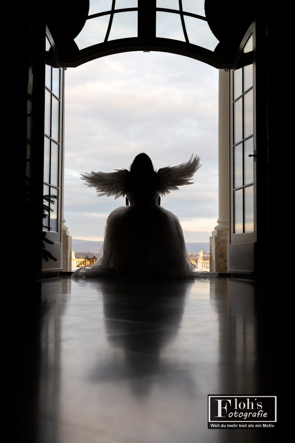 Engel-Cosplay von Vici bei Sonnenuntergang, sanfte warme Farben im Hintergrund.