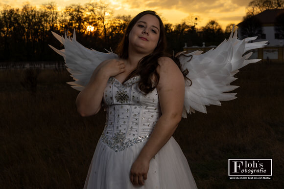 Vici als Engel vor der Fassade der Burg Hof, sitzend und elegant inszeniert.