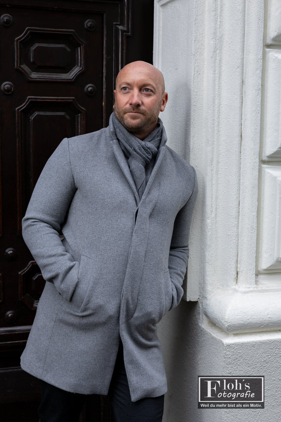 Klassisches Portrait von Gernot vor urbaner Architektur in der Wiener Innenstadt.