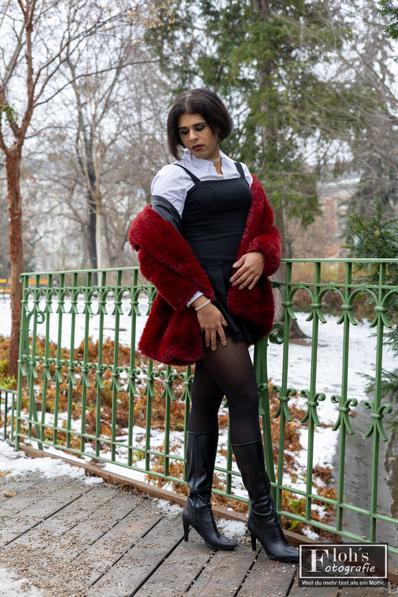 1️⃣4️⃣ Fashion Portrait im Wiener Stadtpark, Arya sitzend mit rotem Mantel und klarem Ausdruck.