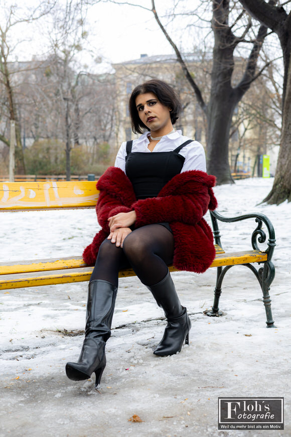 1️⃣7️⃣ Portraitfotografie Wien, Arya im Stadtpark auf moosigem Felsen mit rotem Mantel.